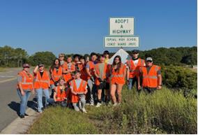 people by Adopt-A-Highway sign